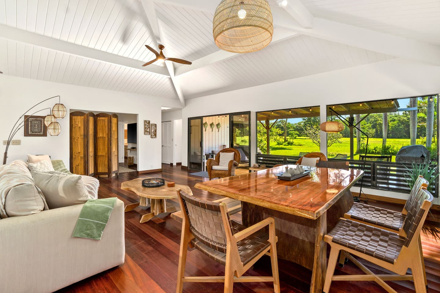 Open-concept living and dining room with vaulted wood ceilings and golf course views at Kamalani Stay, Princeville, Kauai